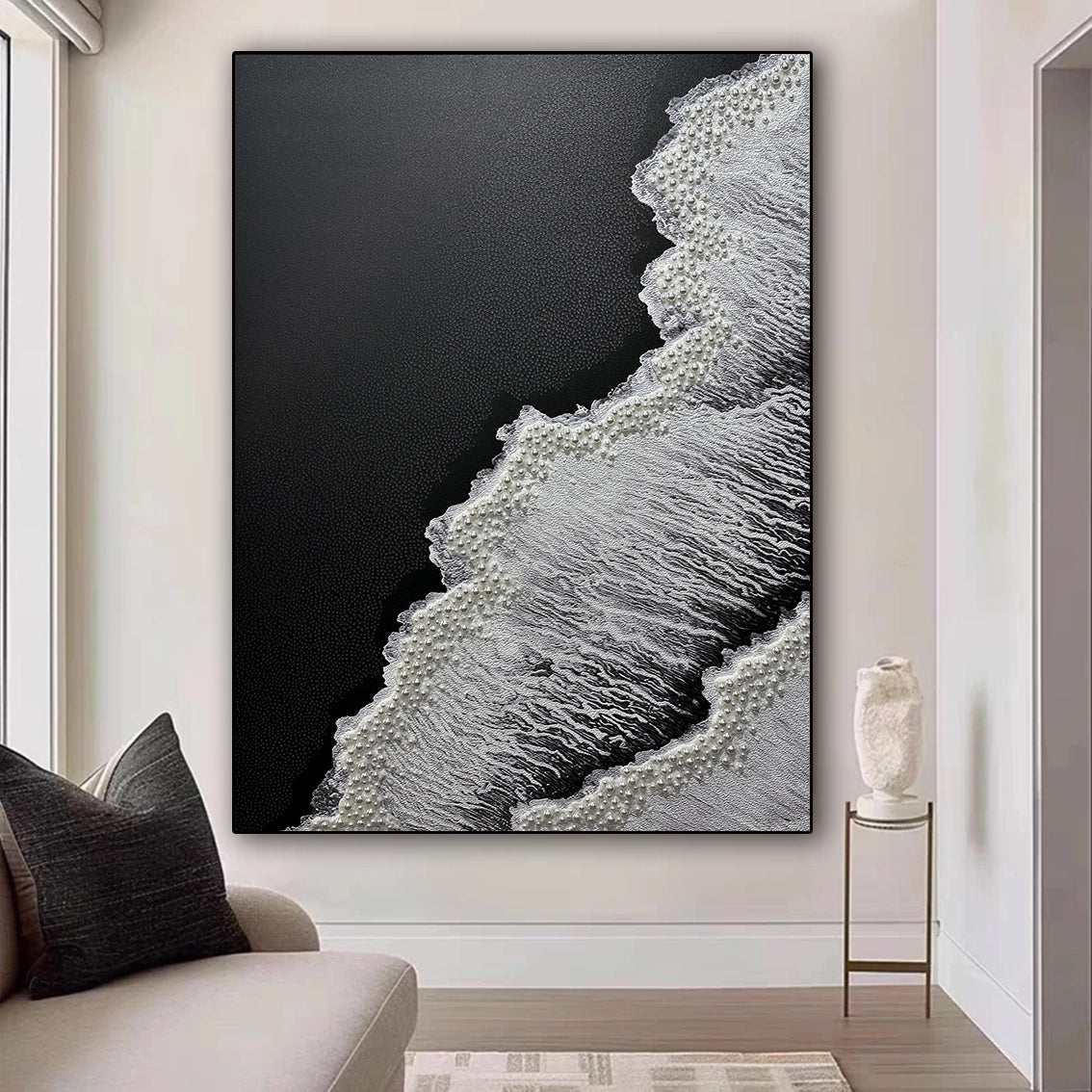 Textured black white wall art with pearl inlay, adding refined elegance to a softly lit minimalist interior.