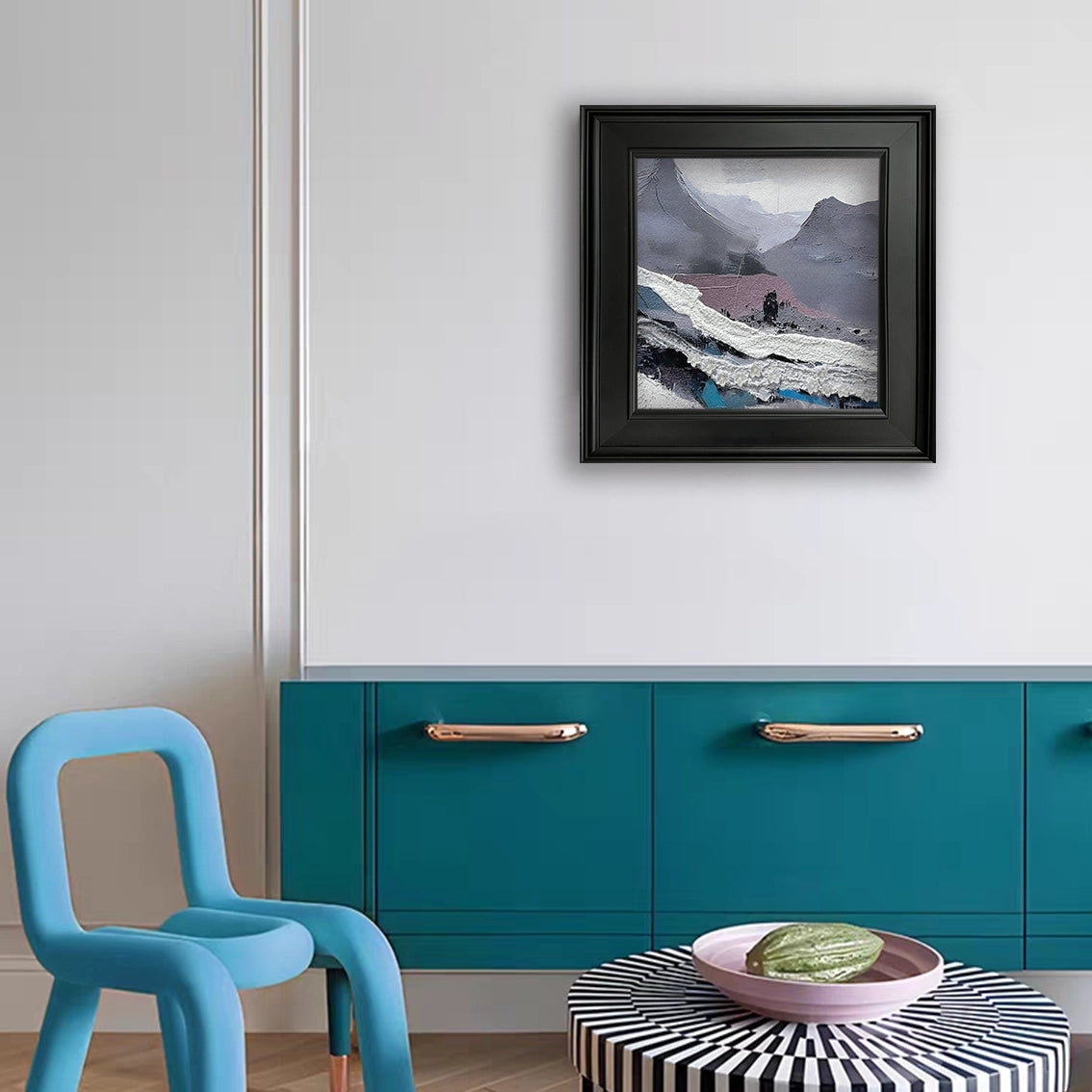 Heavy-texture mountain wall art with floral relief hanging above blue cabinet, modern home decor.