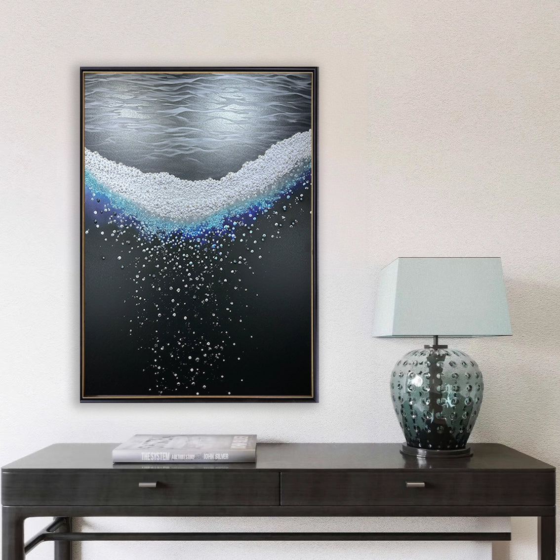 Textured wall art with pearl and crystal design displayed above a console table in a minimalist room.